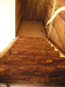 a staircase in a wooden cabin with wooden floors at Lonni Nature Eco-Accommodation in Hagudi