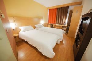 a hotel room with a bed and a dresser at Ibis Yaroslavl Center in Yaroslavl