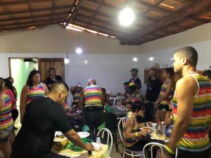 Pousada Recanto Verde في موسوجي: مجموعة من الناس واقفين في غرفة مع طعام