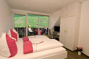 a bedroom with a bed with red and white pillows at Weinhaus Burg-Schneider in Reil