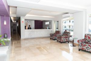 a lobby with chairs and a counter in a building at Hotel Impala -Atras del ADO in Veracruz