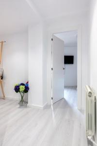 a white room with a door and a vase of flowers at Carmen Apartment in Valencia