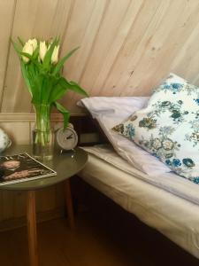 a bed with a vase of flowers and a table at U Haliny - Blisko Term & Gorącego Potoku in Szaflary