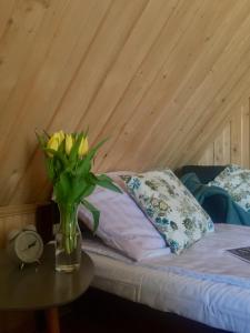 a vase of flowers on a table next to a bed at U Haliny - Blisko Term & Gorącego Potoku in Szaflary