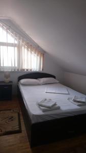 a bedroom with a bed with white sheets and a window at Casa Antonia in Vama Veche