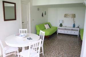 a living room with a table and a green couch at Casa Vacanza Anacapri Sunrise in Anacapri