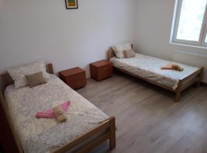a room with two beds and two night stands at Apartman Miljkovic in Arandelovac