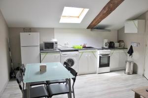 a kitchen with white appliances and a table with chairs at Appartement Boucou in Buanes