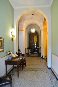 una habitación con una mesa y un pasillo con un arco en Relais Real Collegio en Noli