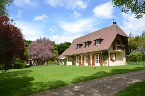 una casa con un gran patio con césped verde en Le Clos Fleuri en Giverny