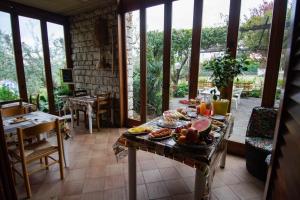 a table with food on it in a room with windows at El Rincon del Artista in Soiano del Lago