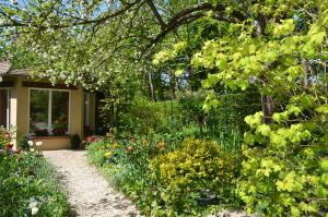 un jardin fleuri et une maison dans l'établissement Le Clos Fleuri, à Giverny