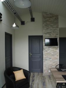 a living room with a black door and a stone wall at GITE AUX P'TITS OIGNONS in Les Herbiers