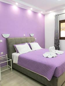 a purple bedroom with a bed with a purple wall at Valeriana Studios in Parga