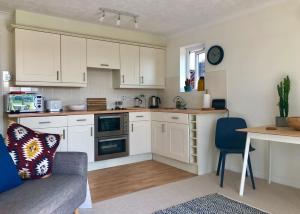 ライにあるWatersideの白いキャビネット、テーブル、ソファ付きのキッチンが備わります。