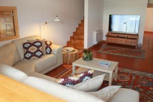a living room with a couch and a tv at Casa da Rosa in Paredes de Coura