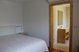 a bedroom with a bed and a sink and a mirror at Casa da Rosa in Paredes de Coura