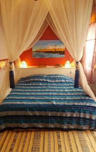 Un dormitorio con una cama grande con dosel. en Riad Terre d'Azur, en Essaouira 11 fotos más