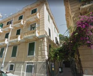 Un edificio con flores moradas en el frente. en Limoncello Rooms, en Salerno