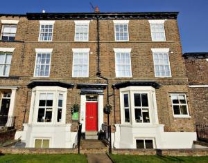 un grand bâtiment en briques avec une porte rouge dans l'établissement The Apple House, à York