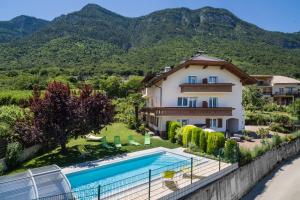 a villa with a swimming pool and mountains in the background at Gästehaus Thaler in Caldaro