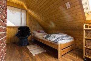 a small room with a bed in a wooden cabin at Domek nad Odrą in Gryfino