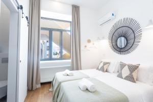 ein weißes Schlafzimmer mit einem Bett und einem Spiegel in der Unterkunft Alameda Exclusive House in Faro