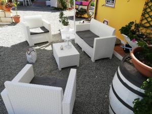 a group of white chairs and tables in a yard at La Gramigna Villette in Briatico