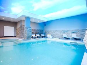 a pool in a hotel with blue walls and chairs at SALA COMACINA RESIDENCE NO 4 in Sala Comacina