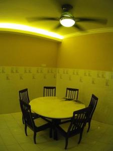 a yellow room with a table and chairs and a ceiling at My 2nd Home in Melaka