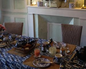 a dining room table with a blue and white table cloth at La Maison Céladon in Prunay-Cassereau