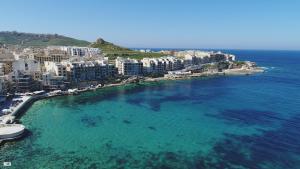 an aerial view of a beach with buildings and the ocean at Pebbles, apartment 1 in Marsalforn