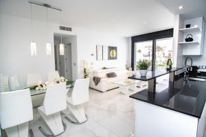 a white living room with white chairs and a table at Infinity View Paradise Apartment in Arenales del Sol