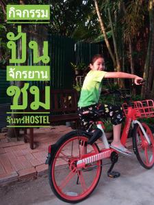 a woman is sitting on a red bike at Chom Chan Guesthouse & Hostel in Chiang Mai