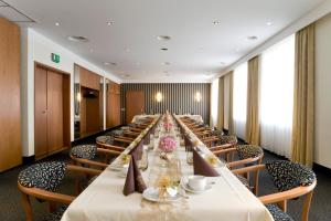 a long long table in a long room with chairs at Hotel Erfurter Tor in Sömmerda