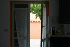 otwarte drzwi do kuchni z oknem w obiekcie I Villini B&B w mieście Fiumicino