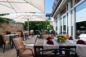 an outdoor restaurant with tables and chairs and an umbrella at Hotel Erfurter Tor in Sömmerda