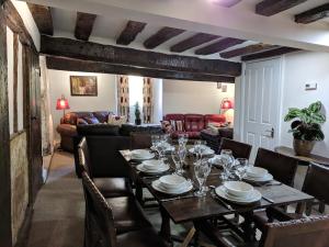 een eetkamer met een tafel en een bank bij Cotswolds Valleys Accommodation - Medieval Hall - Exclusive use character three bedroom holiday apartment in Stroud