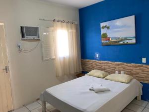 a bedroom with a bed with a blue wall at CP Hotel Economic in Natal