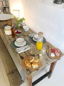 una mesa de madera con productos para el desayuno y zumo de naranja en l'autre maison en Penne-dʼAgenais