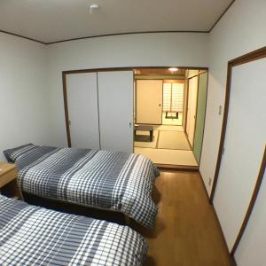 Duas camas num quarto com um espelho em machiyado Kuwanajuku Kawaguchi-cho 8 em Kuwana