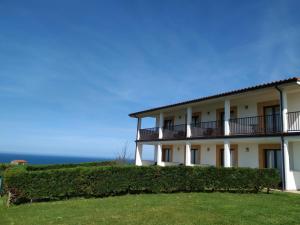 a large white building with bushes in front of it at El Ribero de Langre in Langre