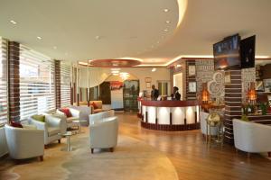 un vestíbulo con sillas blancas y un bar en Eusbett Hotel, en Sunyani