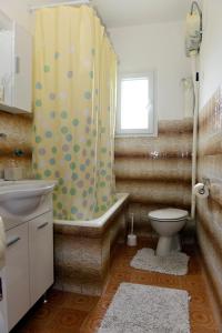 a bathroom with a shower curtain and a toilet at Sobe Tivat in Tivat