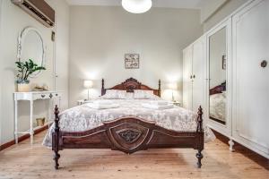 sypialnia z dużym drewnianym łóżkiem w pokoju w obiekcie Bella Venezia Residence w Korfu