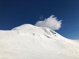 a snow covered mountain with a cloud in the sky at Hotel Gran Baita in Gressoney-Saint-Jean