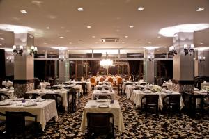 a dining room filled with tables with white table linens at Hotel Bertaso in Chapecó
