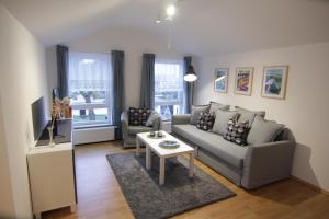 una sala de estar con un sofá y una mesa en Strandnahe Ferienwohnungen mit Garten, en Ostseebad Koserow