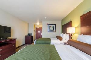 a hotel room with two beds and a flat screen tv at Cobblestone Hotel & Suites - McCook in McCook