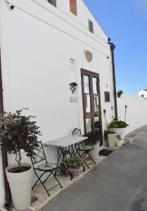 a table and chairs outside of a white building at ADRIANA in Pisticci +8 photos